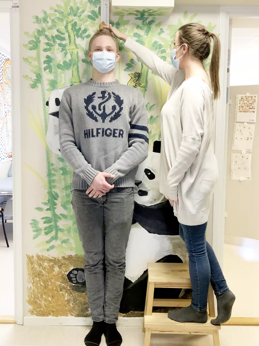 En forskningssjuksköterska får stå på en pall när hon ska mäta hur lång Alexander är. Foto: Sara Liedholm