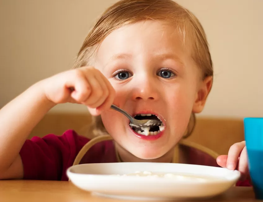 Illustration till texten om grainstudien. Bilden föreställer en pojke som äter gröt. Foto.